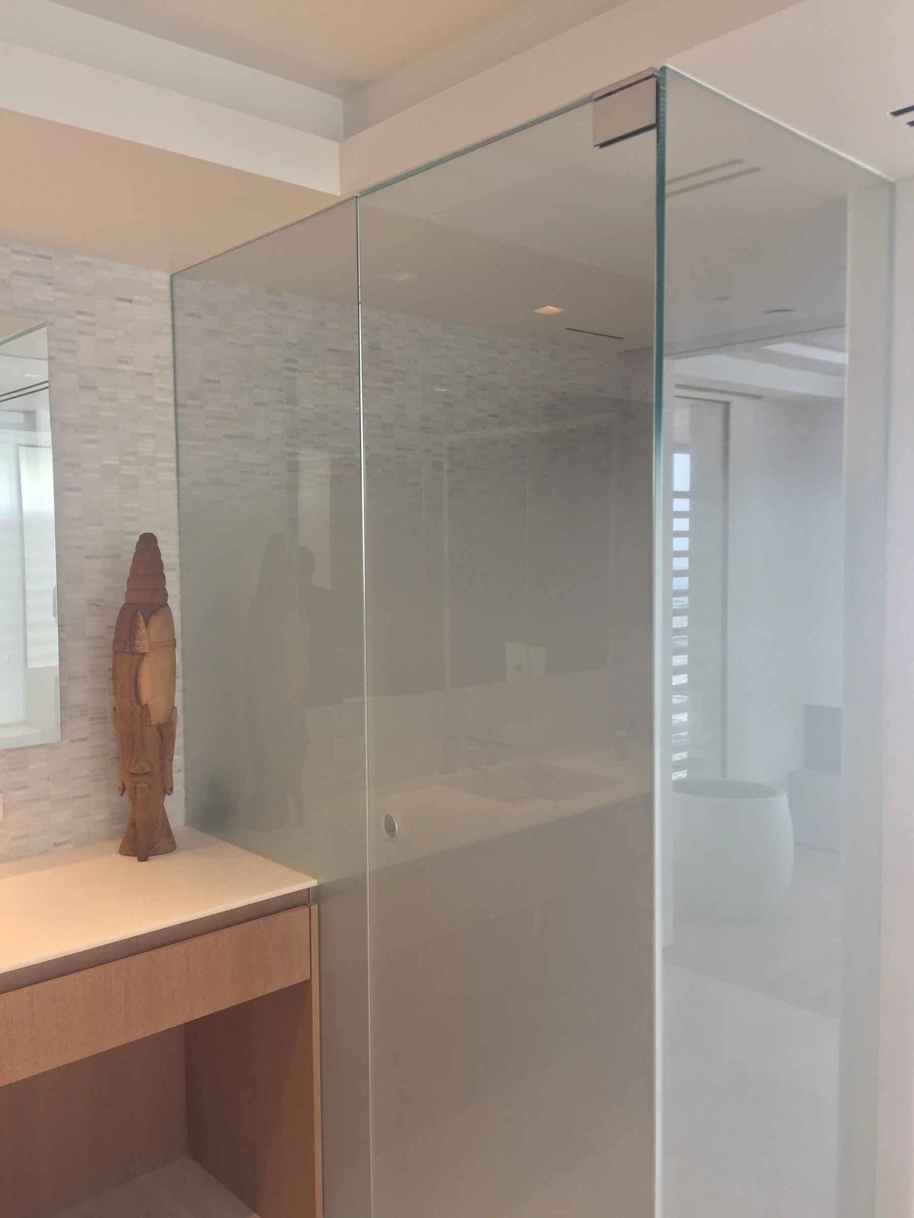 Frameless glass shower enclosure beside a wood vanity