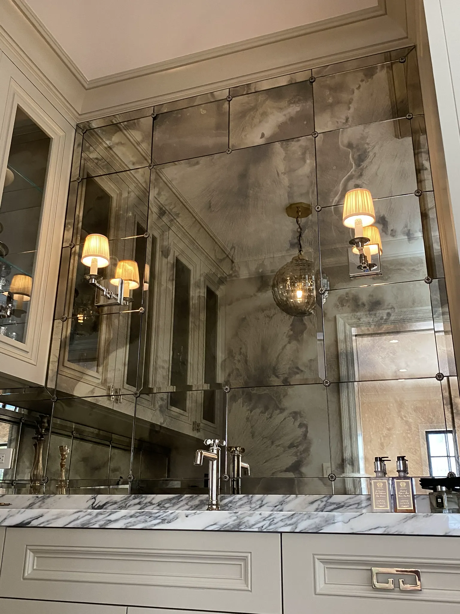 Antiqued mirror wall reflecting pendant lights