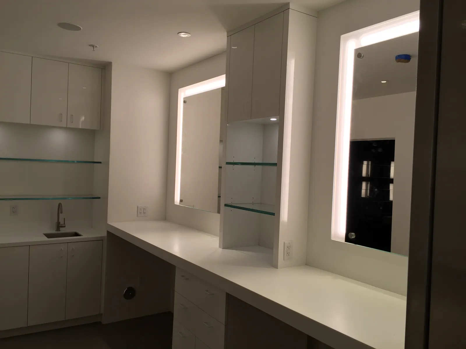 Backlit vanity mirrors with glass shelving