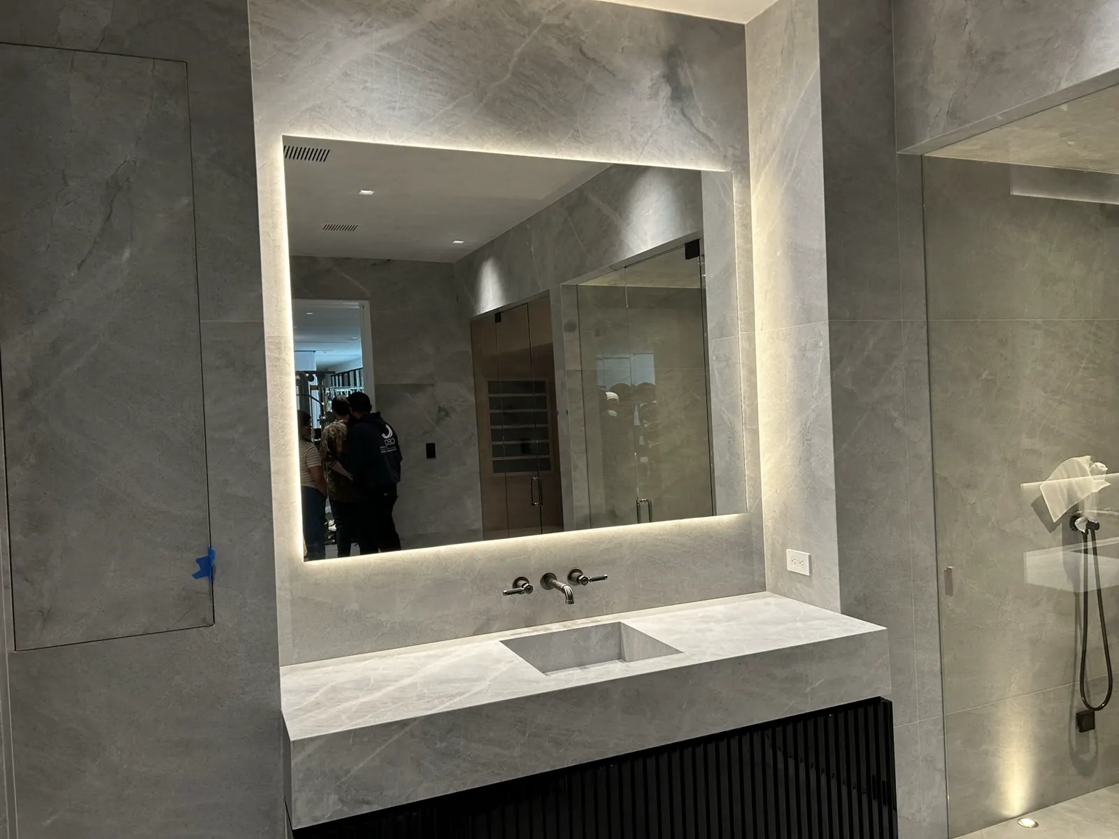 Bathroom vanity with an illuminated-border rectangular mirror