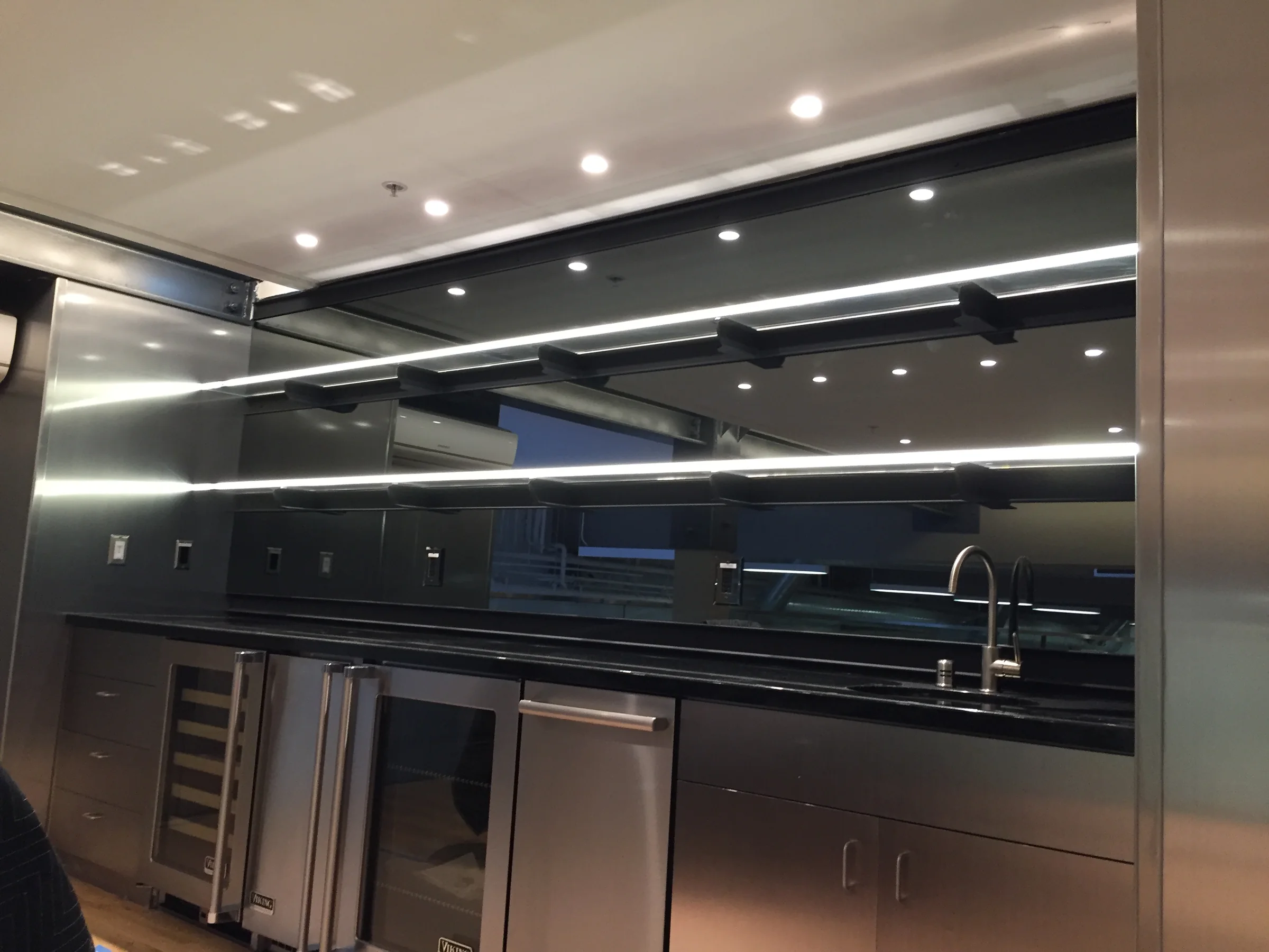 Backlit mirrored bar with glass shelving