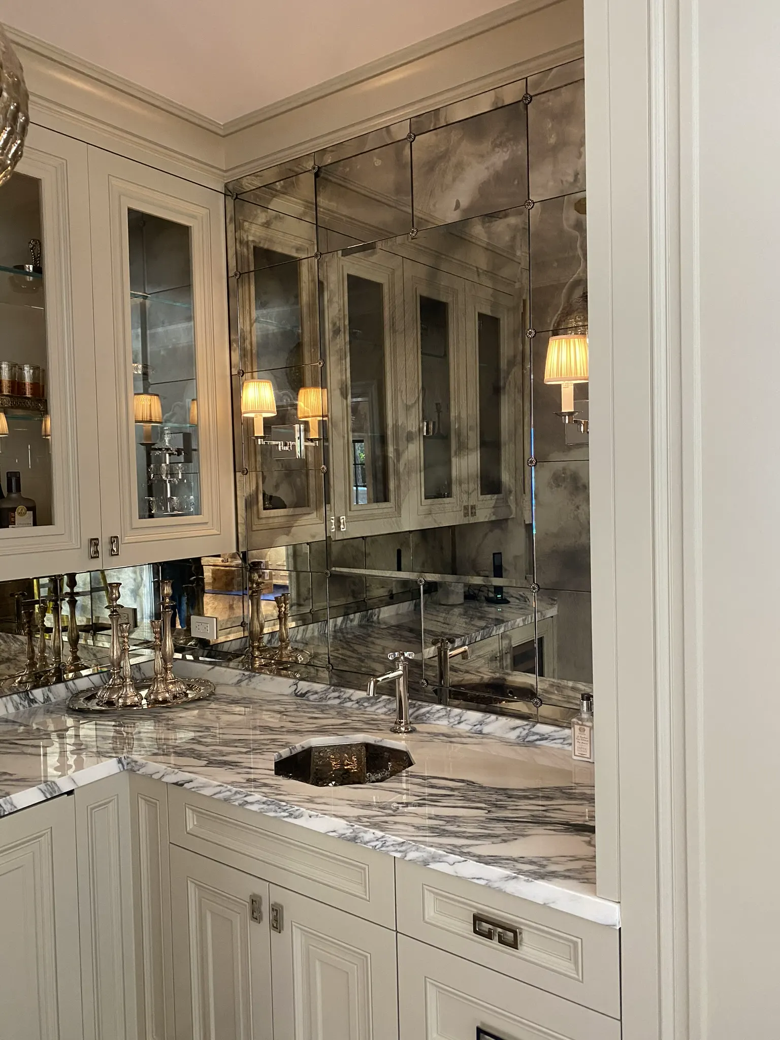 Antiqued mirror panels above cabinetry at a bar