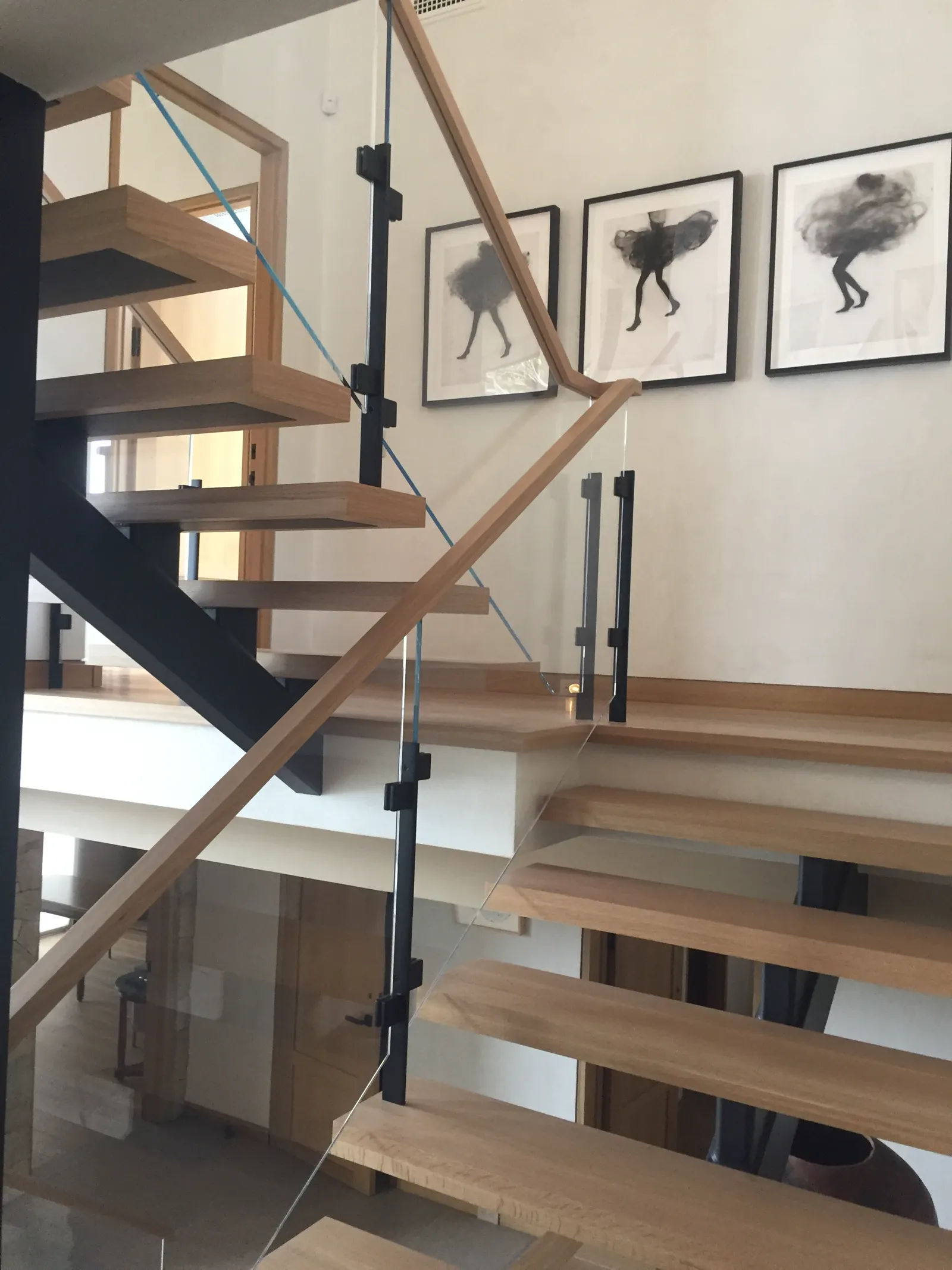 Wooden staircase with a glass railing and wood handrail