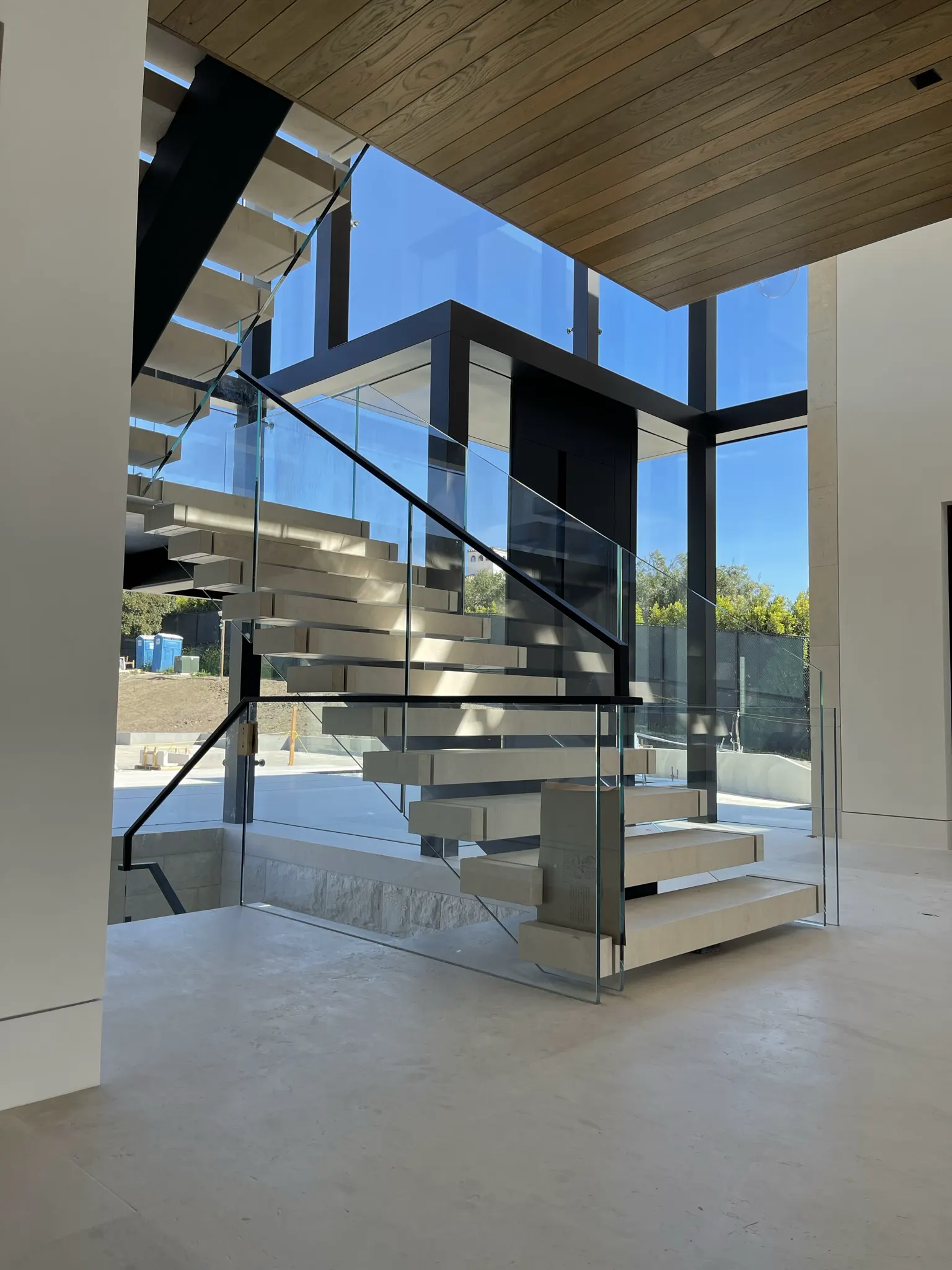 Bright modern interior staircase with clear glass railings