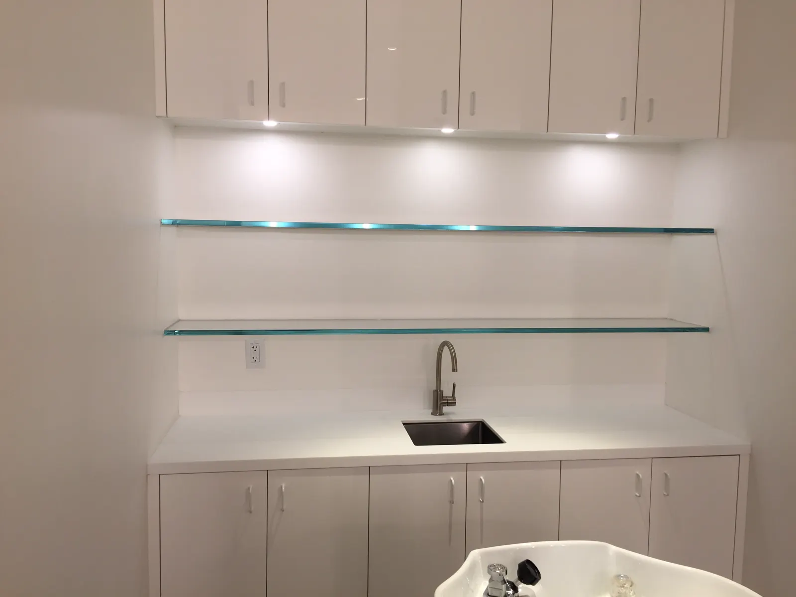 Floating glass shelves mounted on a white wall