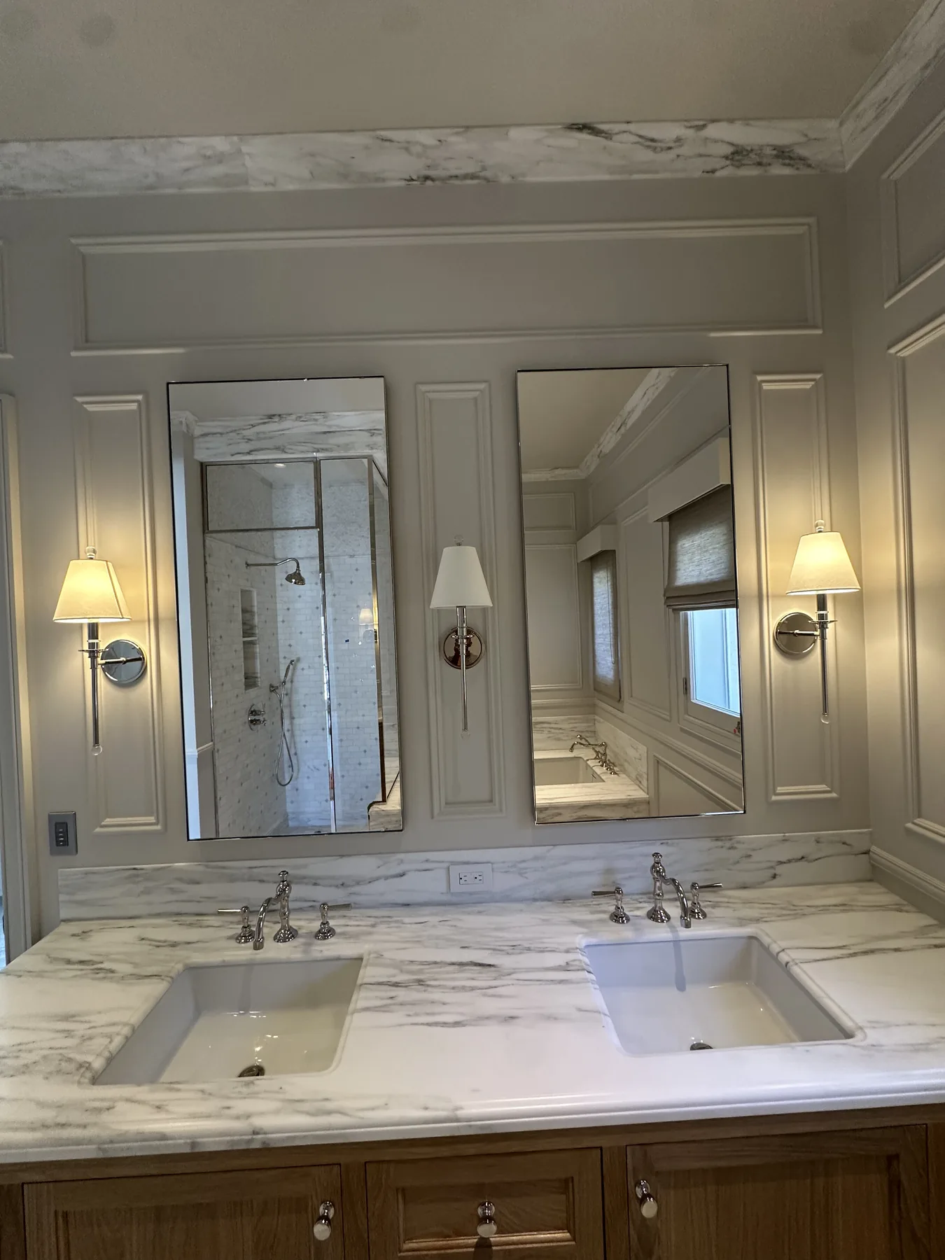 Pair of custom frameless mirrors over a marble double vanity